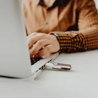 USB-флеш-накопитель, подключённый к ноутбуку, — крупный план